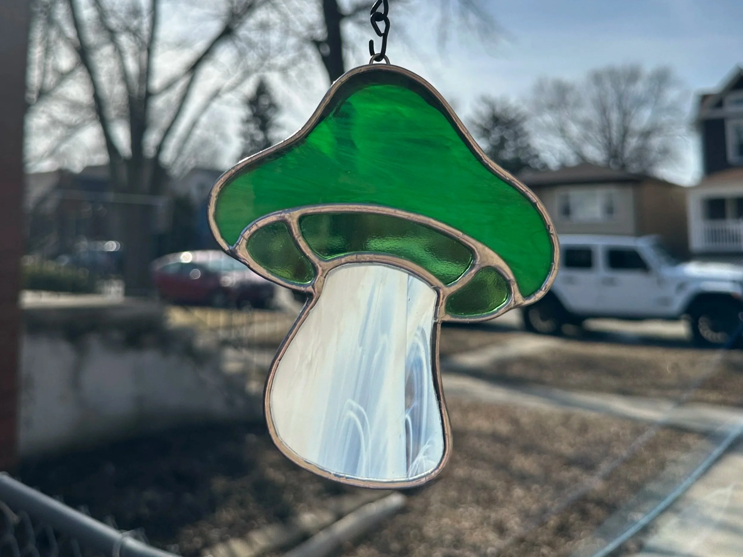 Mushroom stained glass sun catcher that is made of green glass and used the copper foil method to solder and foil the pieces together for you to make in one class.