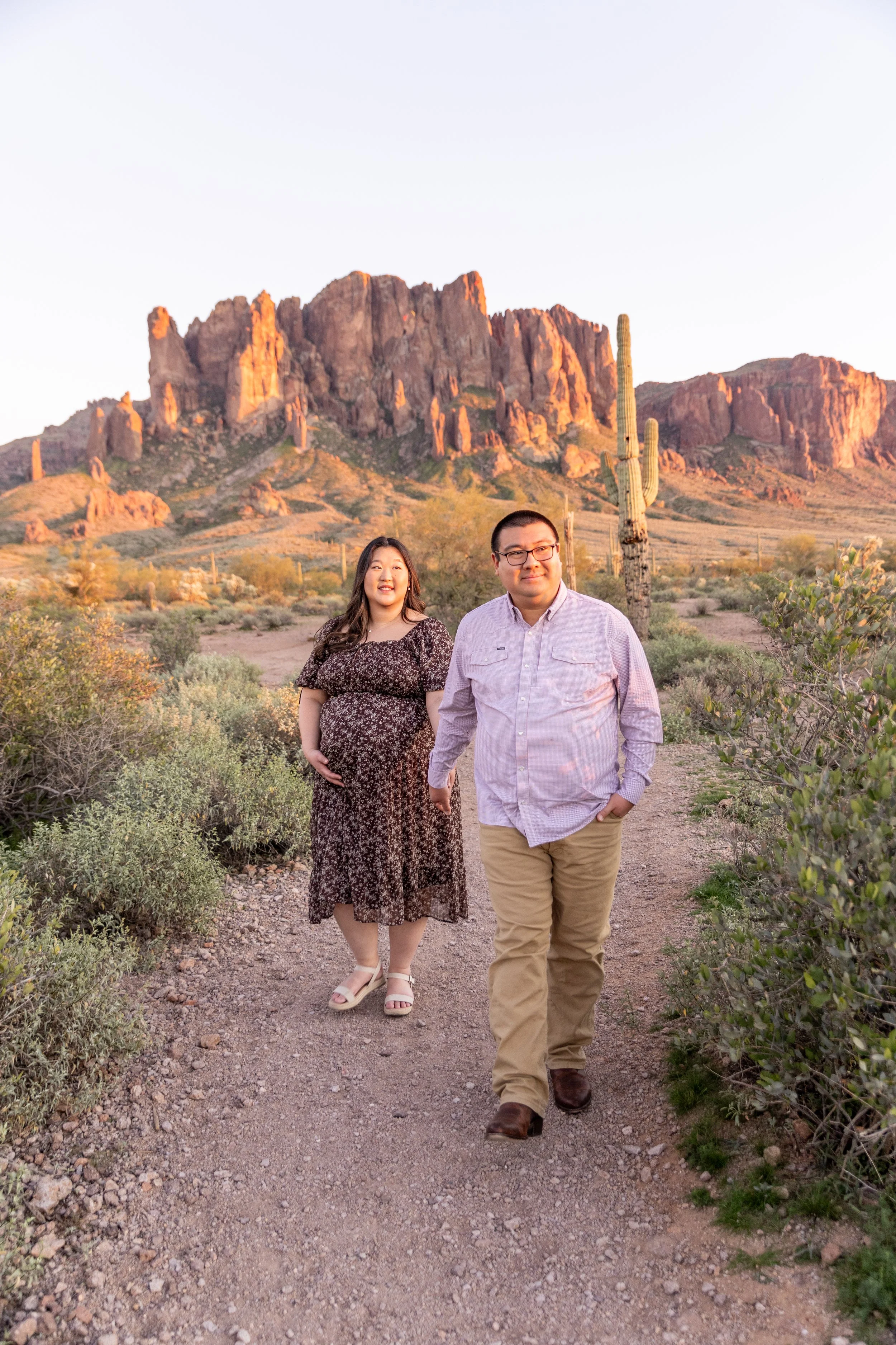 Couple walking during maternity photoshoot at Superstition Mountain