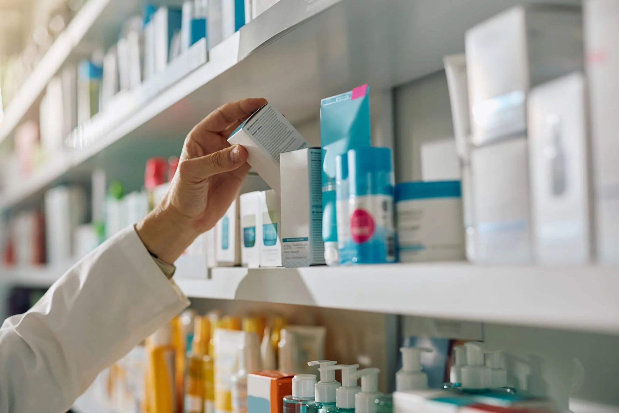 pharmacist taking medicine of a shelf in a pharmacy