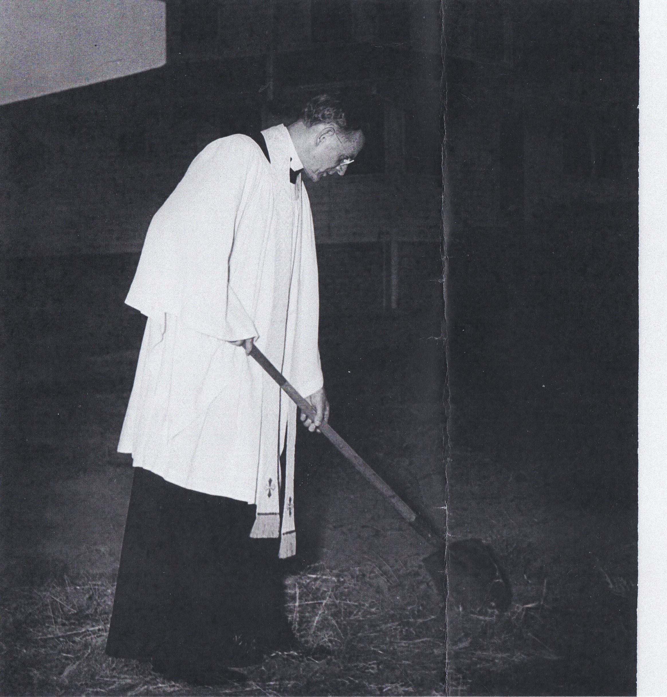 Father Cander breaks ground for the new church building.