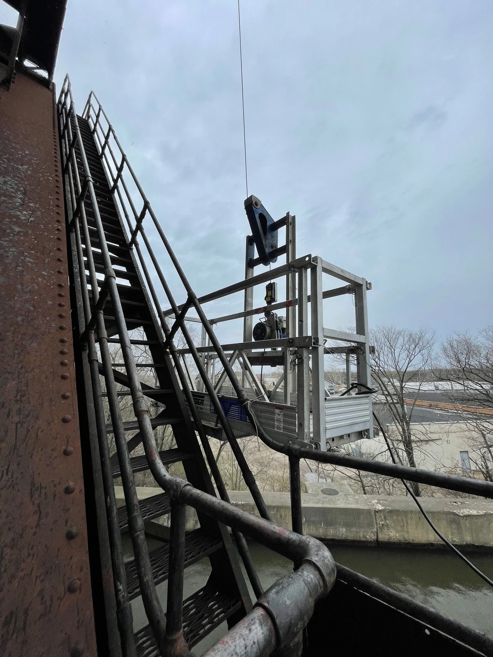 Suspended basket on train bridge tower over the Des Plaines River. - Black Cat Scaffold