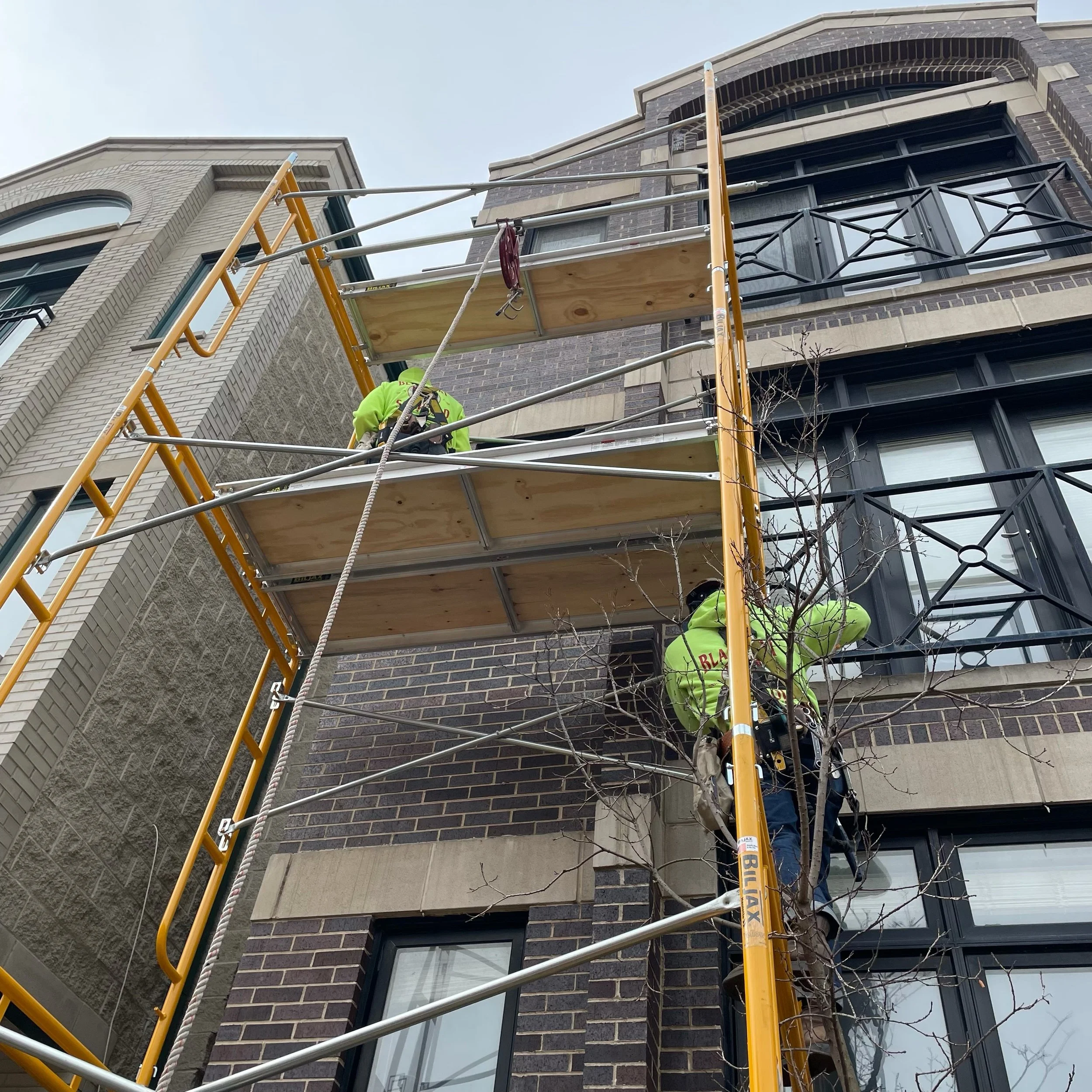 Erecting 5'W x 7'L x 35'H garbage chute for roofers. - Black Cat Scaffold