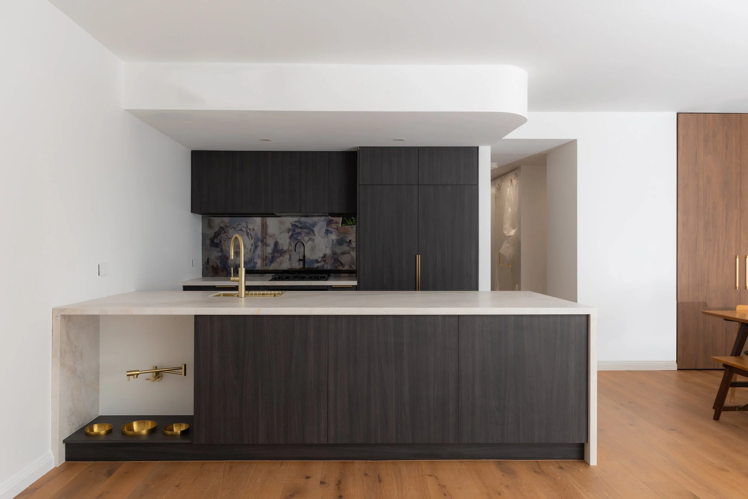 Renovated St Kilda West apartment kitchen with blue natural stone feature and timber joinery