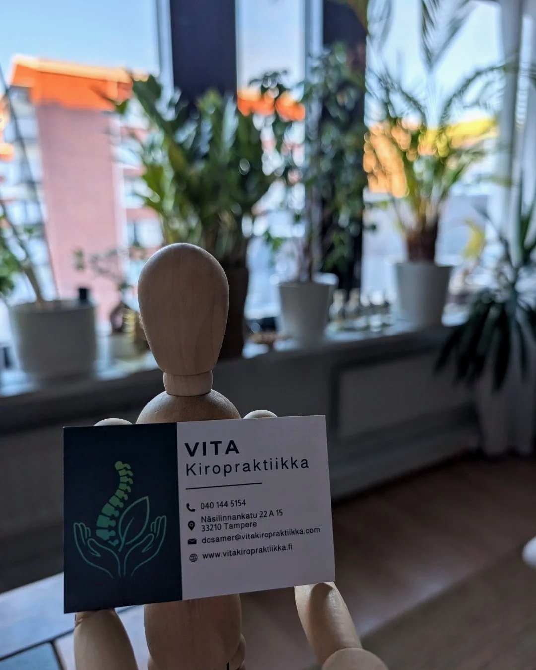 Koriste-esine, joka kannattelee Vita kiropraktiikan käyntikorttia