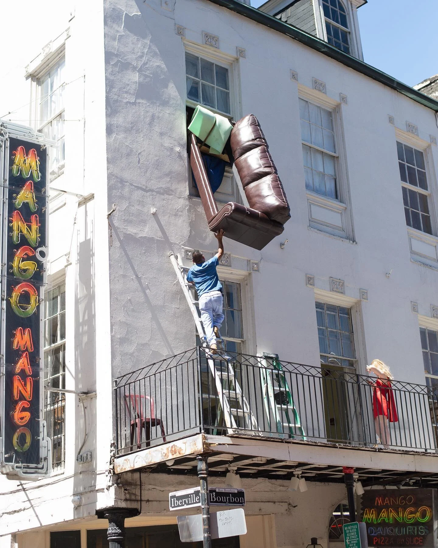 This is what move-in day looks like in the French Quarter. A small crowd formed with me on Bourbon Street to watch how the couch would get into the window. They did it, too! #frenchquarter #bourbonstreet #nolastreetphotography #streetphotography #str