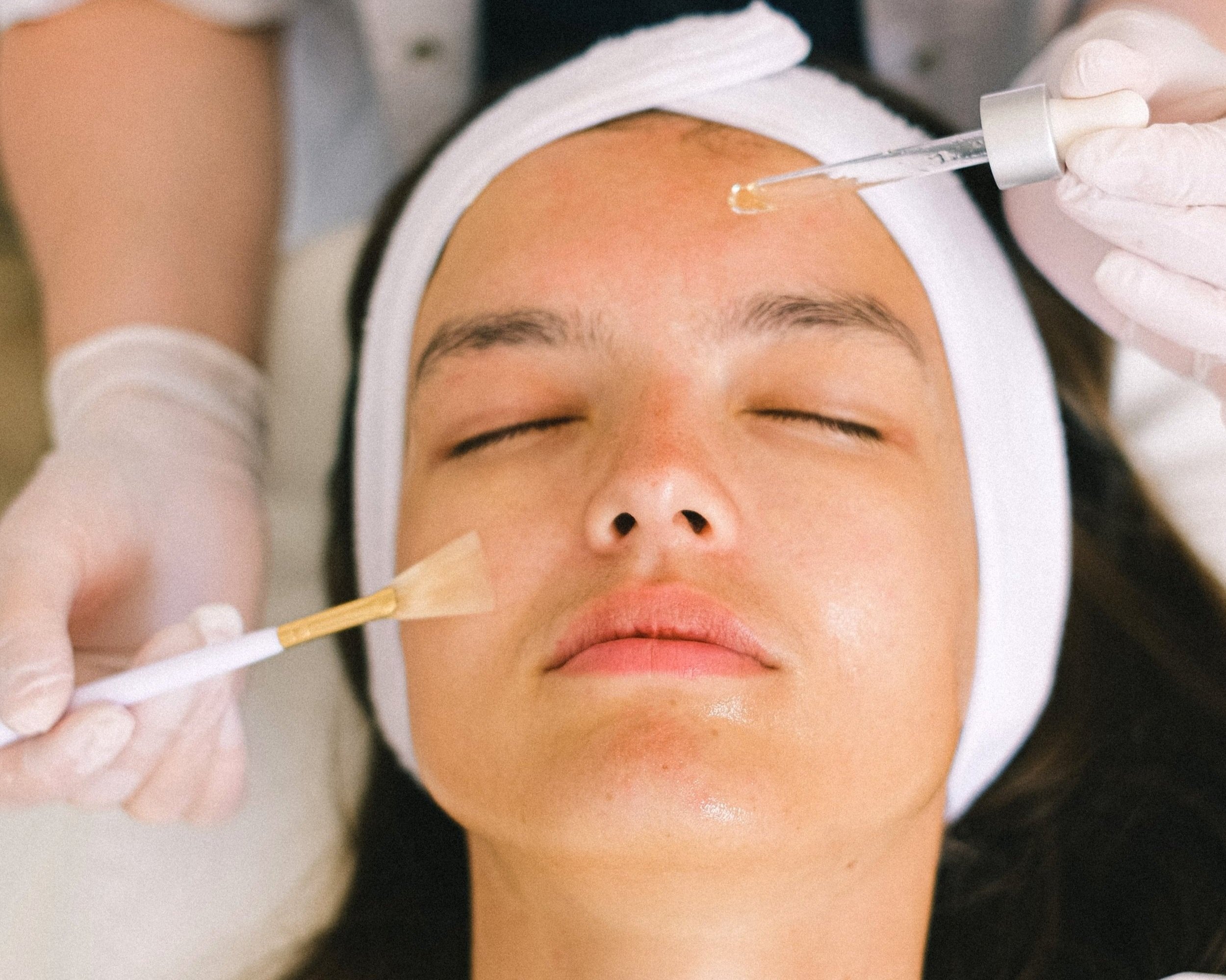 Facial treatment, with a skincare professional applying a facial mask