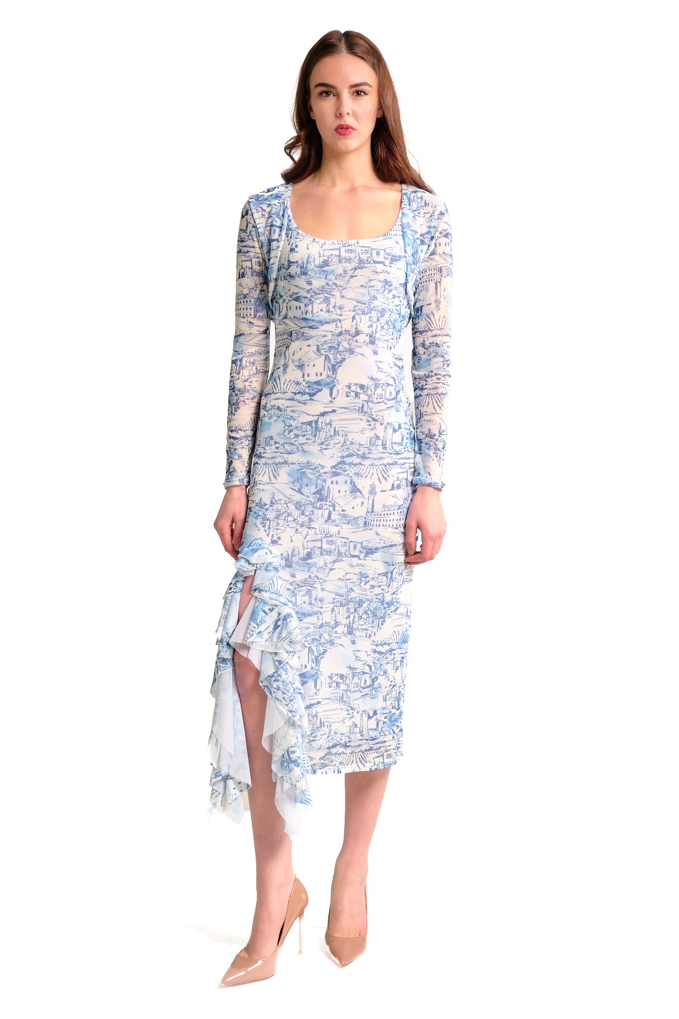 Woman wearing a long-sleeved dress with a blue and white scenic print, standing with her arms at her sides, and beige high heels.