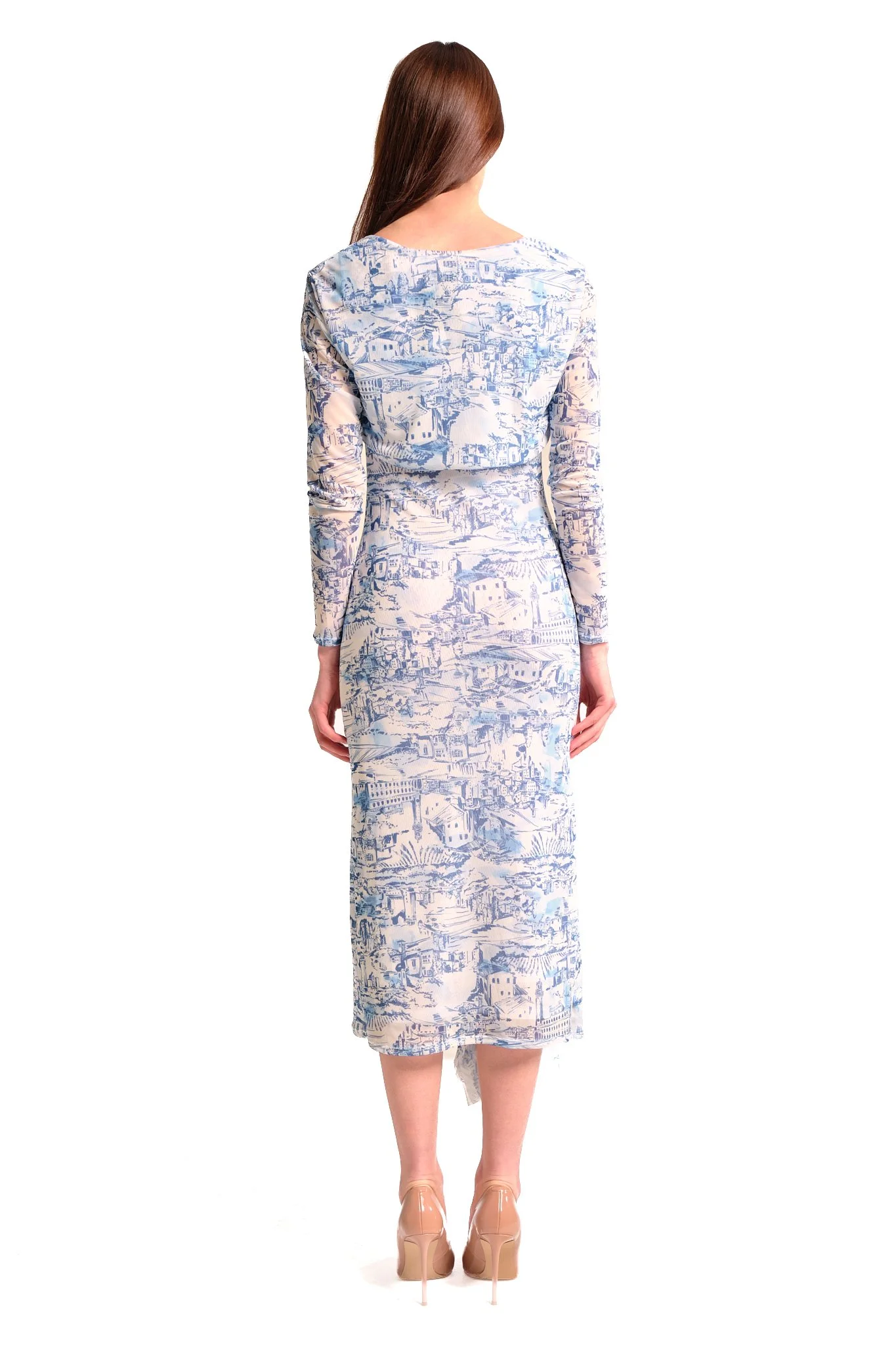 Back view of a woman in a long, fitted dress with a blue and white scenic pattern and nude high heels.