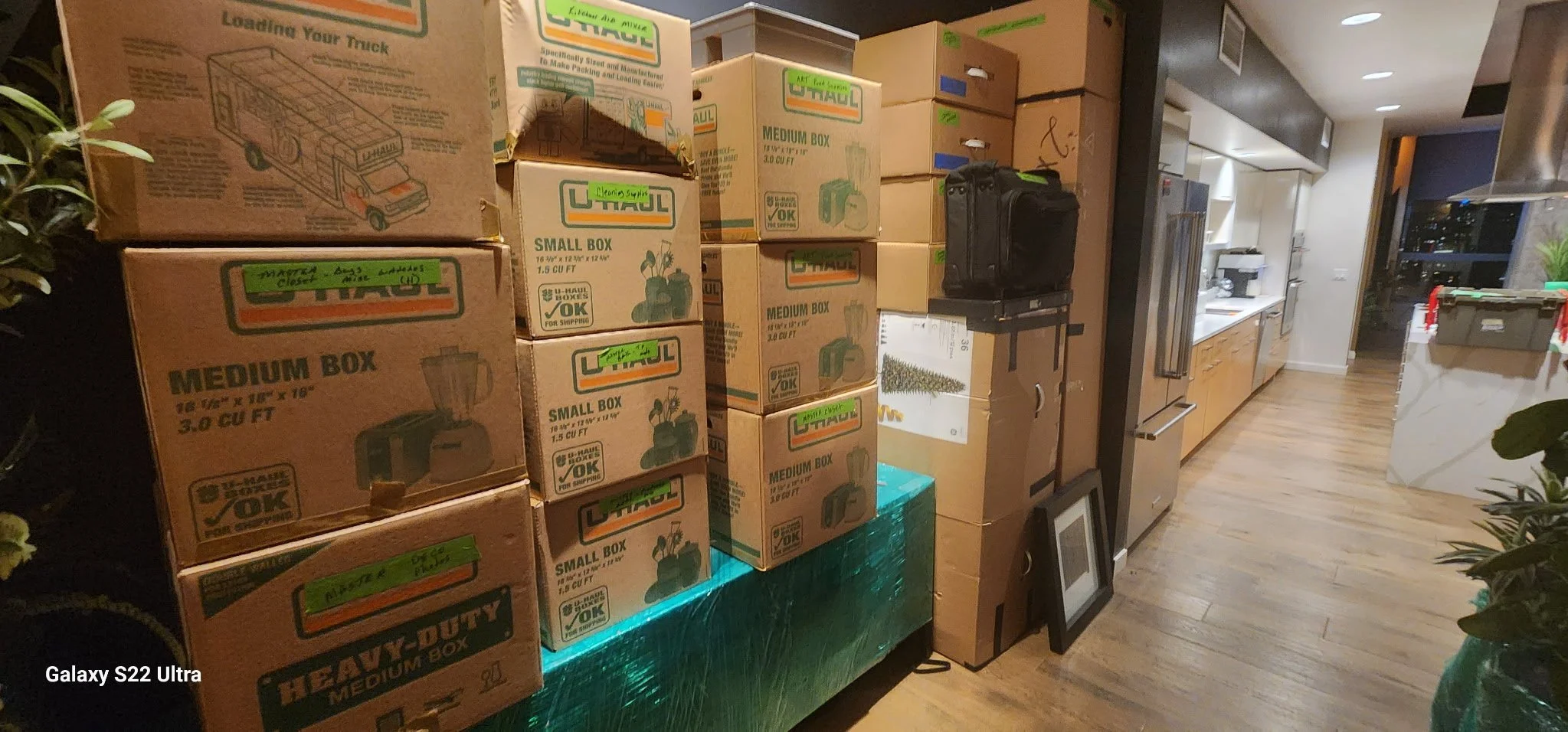 Packed boxes of moving supplies and kitchen cabinets in a modern apartment during move-in or move-out.