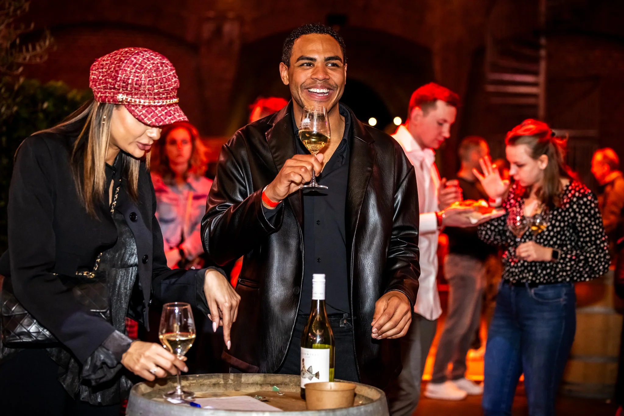 Mensen die wijn drinken en socializen op een feestje in een warme, sfeervolle omgeving.