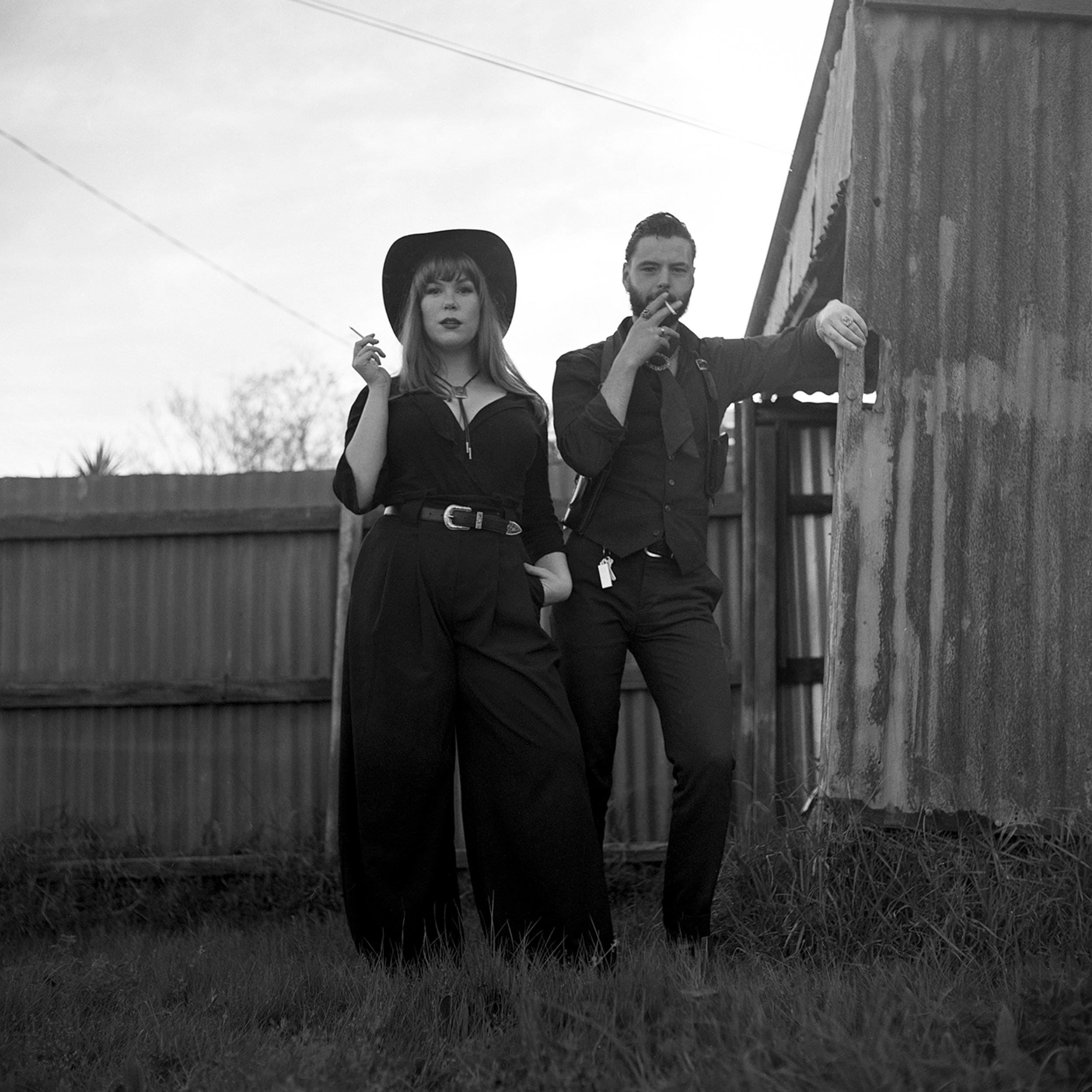 black and white photo of cowboys in a backyard
