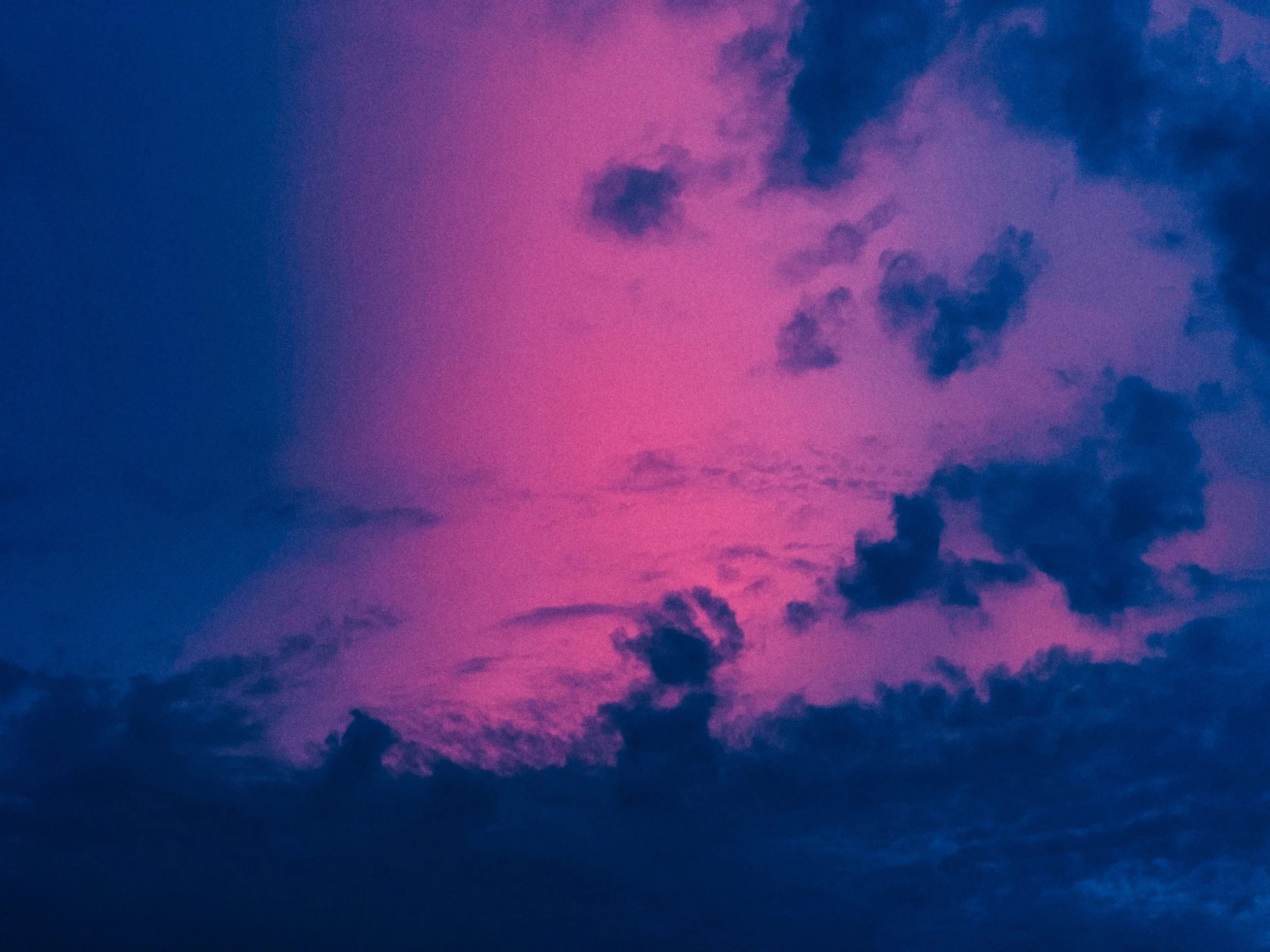 De lucht met een paar wolken tijdens zonsondergang, met roze en paarse tinten.