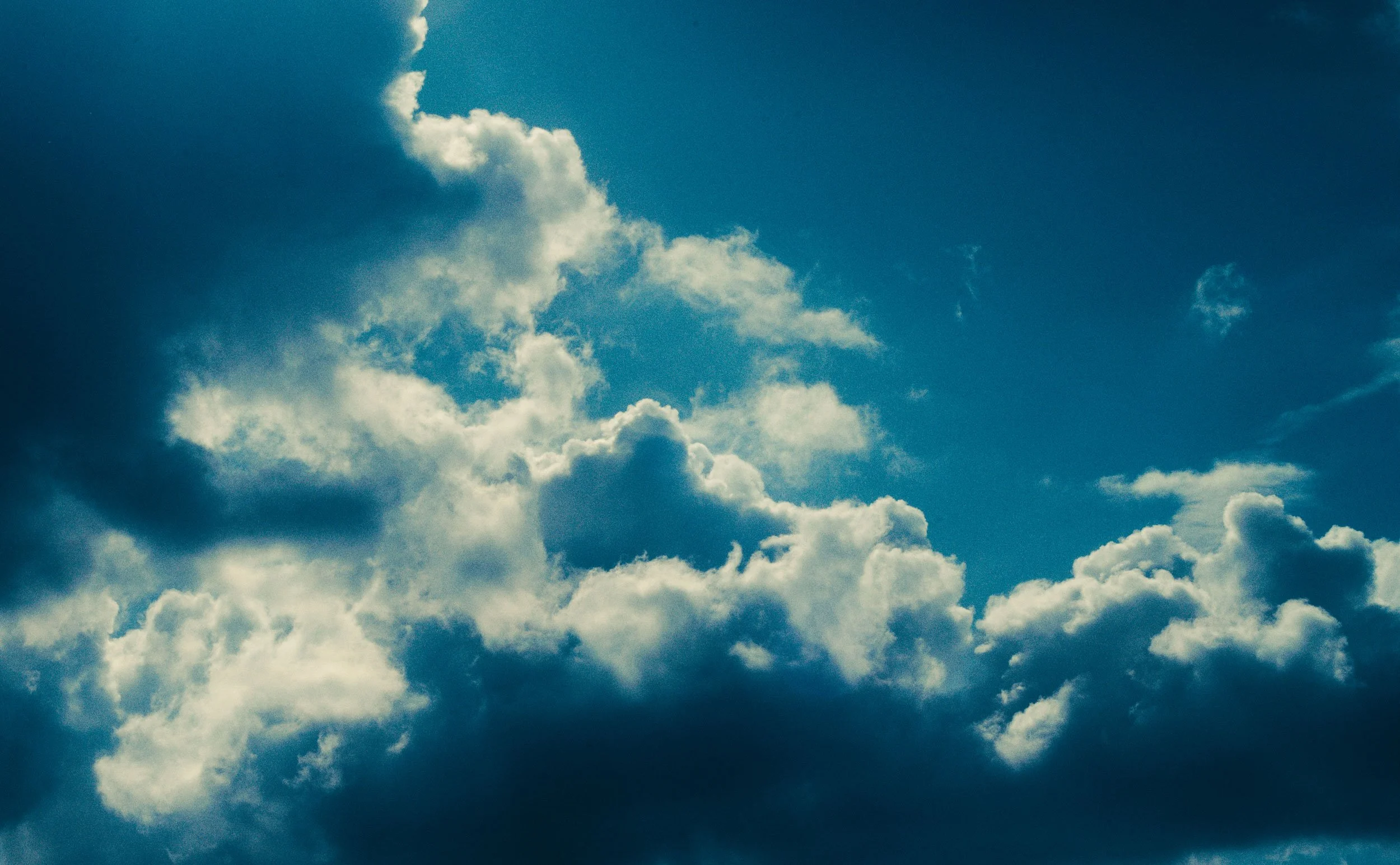 Donkere en lichte wolken in een heldere blauwe lucht.