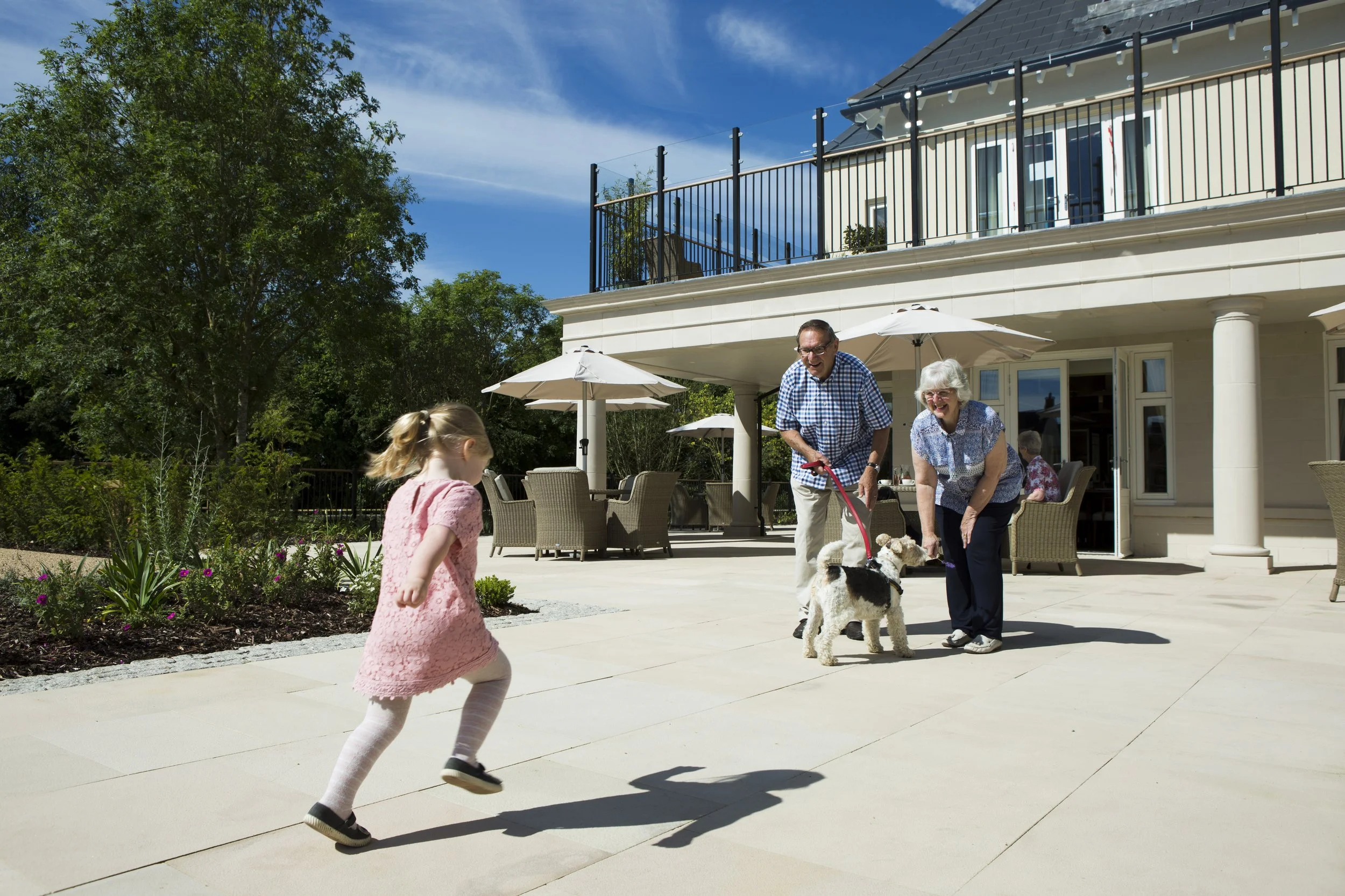 Child with grandparents and dog at luxury retirement village