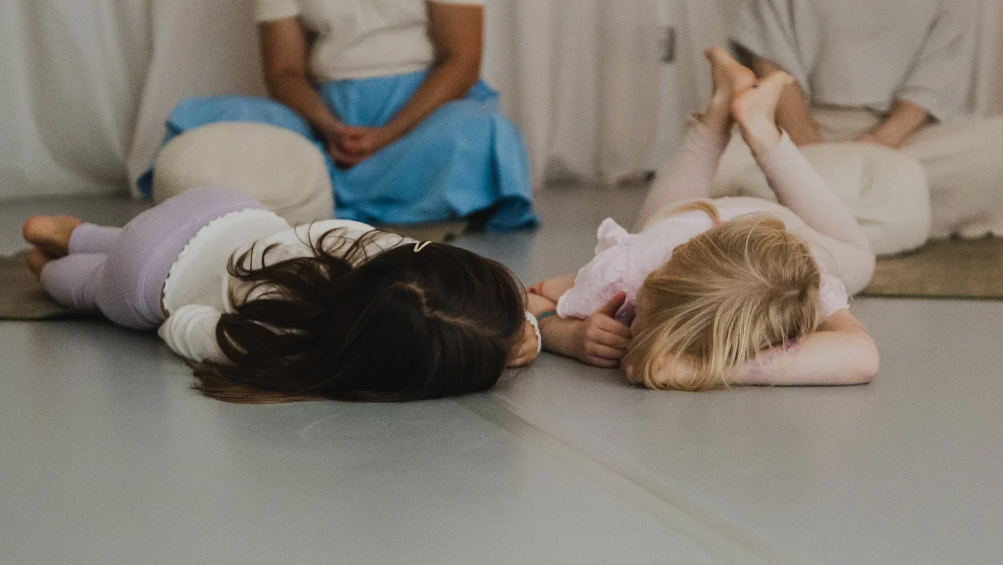 Zwei Mädchen entspannen beim Mama-Kind Mini Retreat in Berlin Prenzlauer Berg im Yoga Studio auf dem Boden