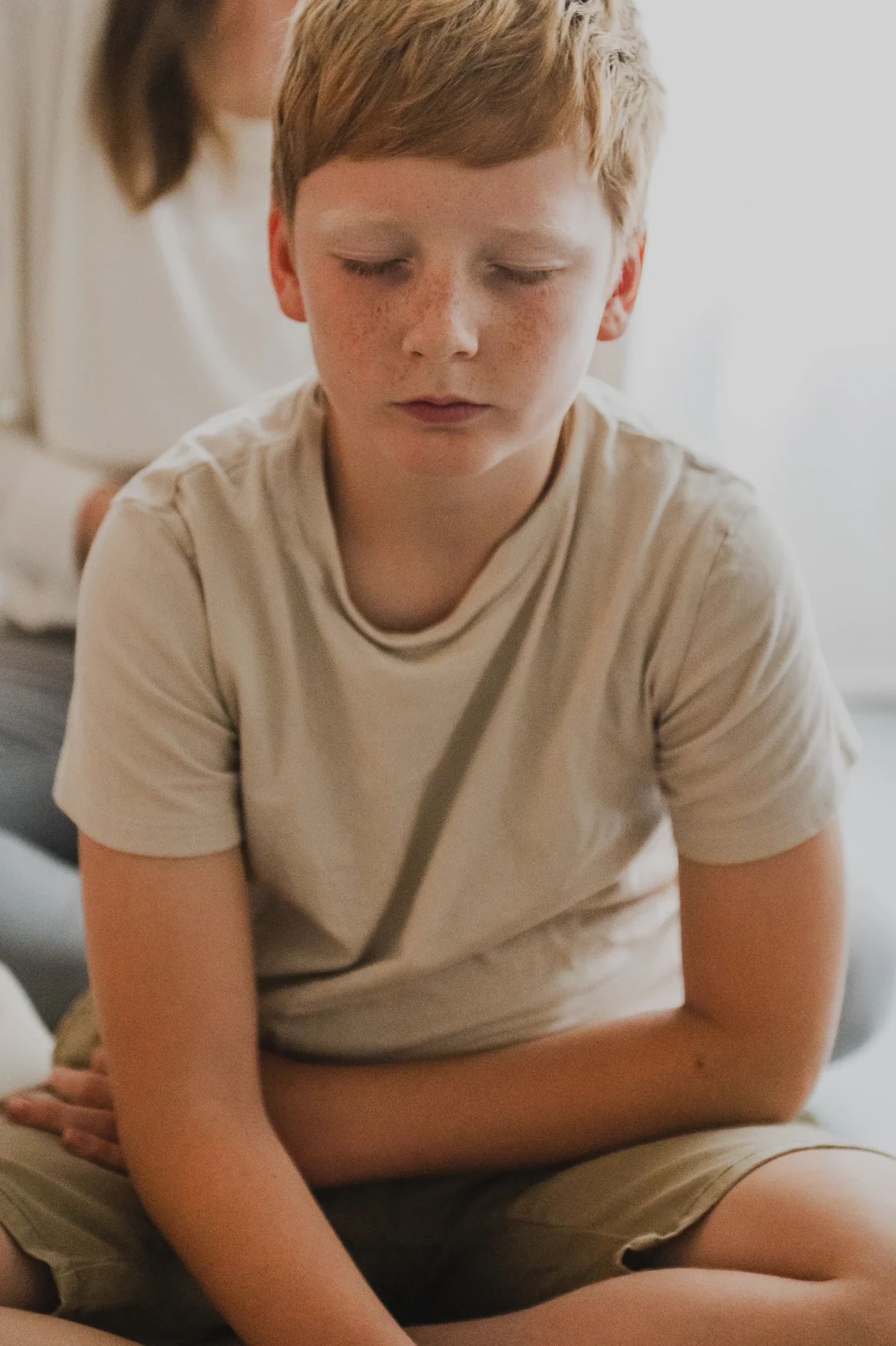 Kind beim Kindercoaching in Berlin. Ein Junge mit geschlossenen Augen folgt einer Coaching Übung für Kinder.