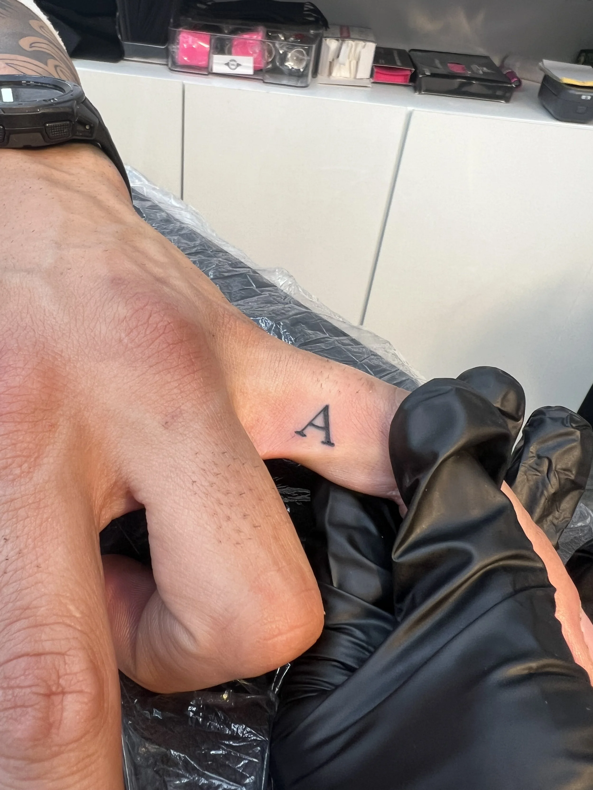 Tiny A tattoo on finger