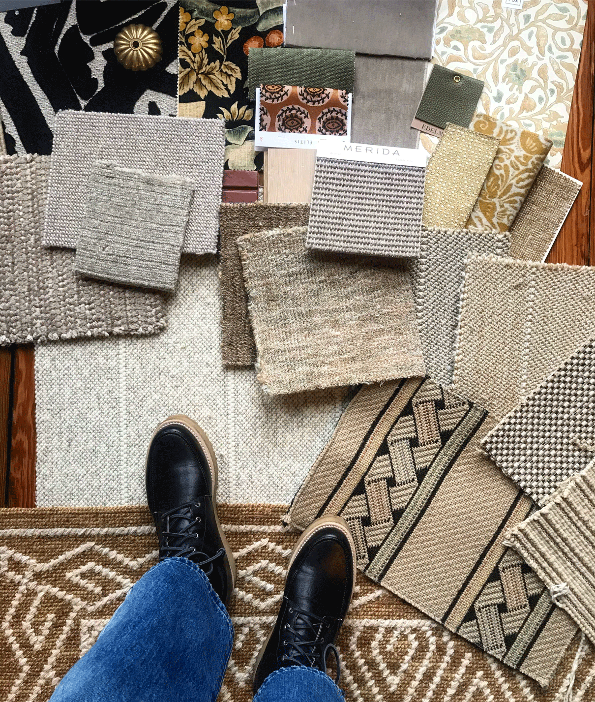 A photo of feet standing on various rug and textile swatches in different shades and patterns