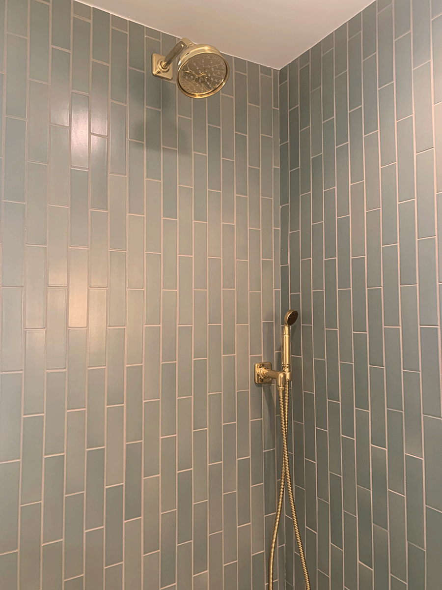 Close up of bathroom tile in blue with gold hardware