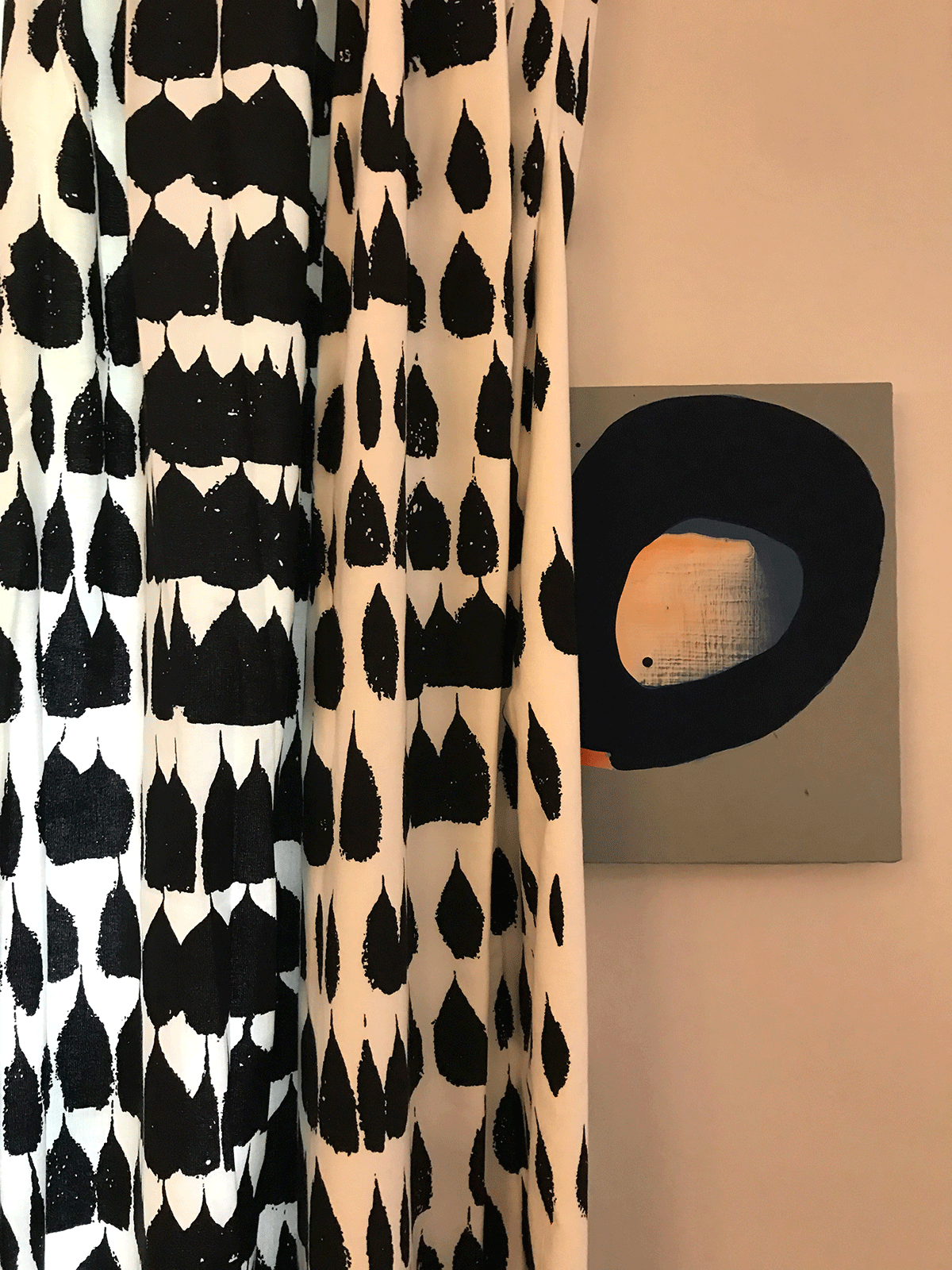 Close up of living-room curtain pattern with black tear drop like shapes on white