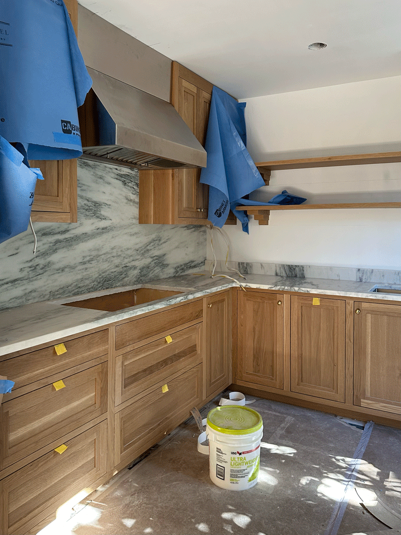 Built ins being installed in a room with black and white checkered tile