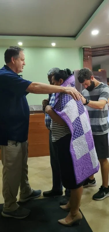 Pastor Randy blessing people with a quilt 3.jpg