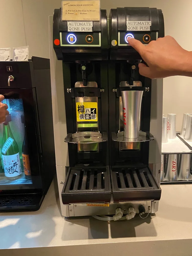 成田空港第2ターミナル ラウンジ 虚空 – KoCoo – 右側ラウンジエリアの生ビールマシーン。専用カップをセットしてボタン操作で注げる