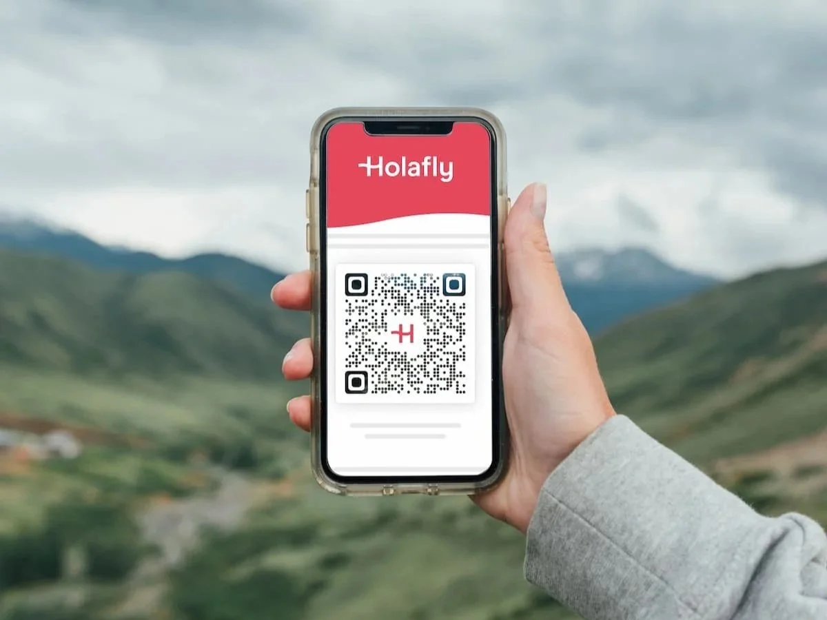 Holafly eSIM QR code displayed on a smartphone outdoors