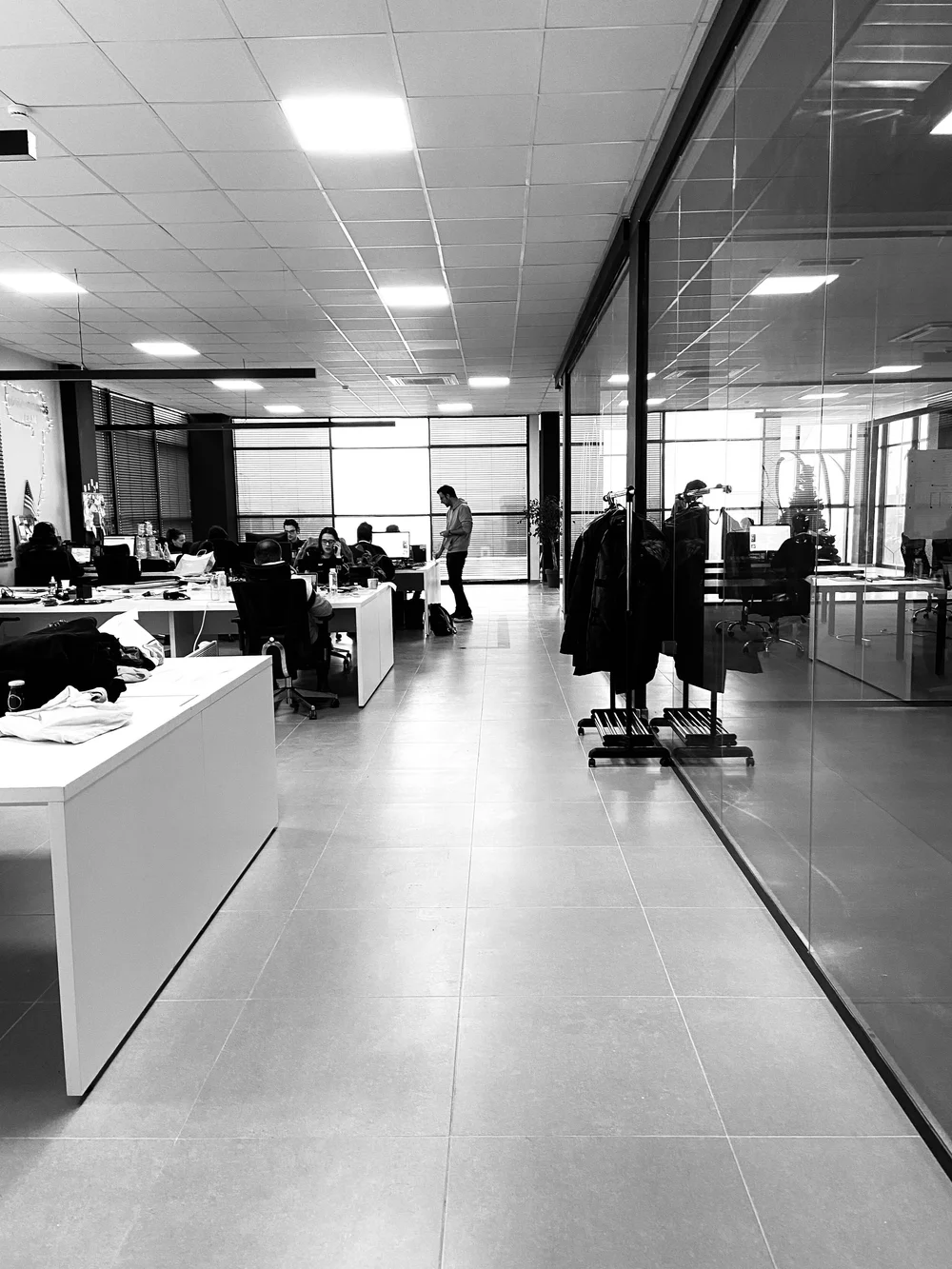 An open studio office with design tables and clothing racks
