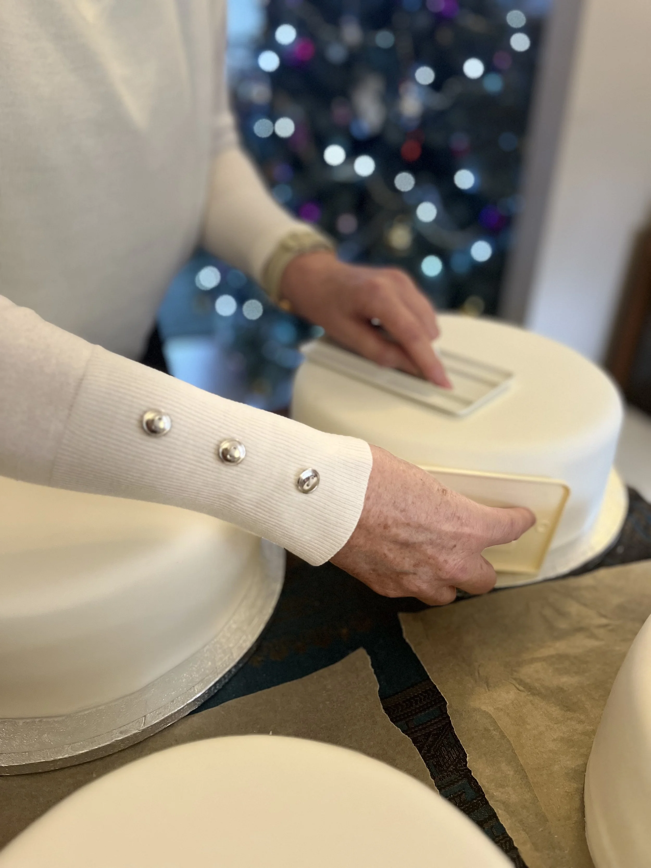 Hands smoothing a cake