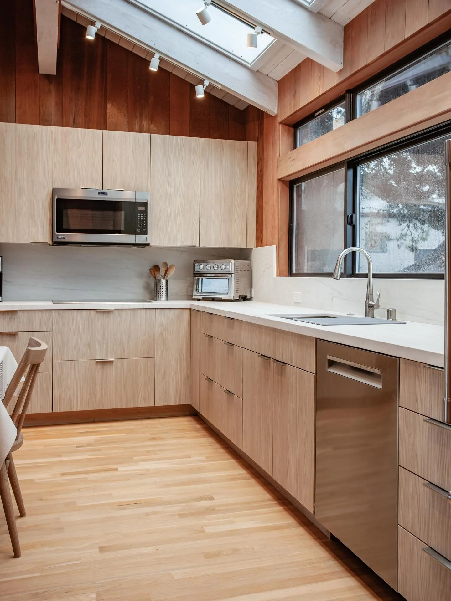 Classic Sea Ranch with a modern update. Complementary wood tones, quiet stone countertops, and a relaxed fireplace built-in come together to create a cool space perfect for reprieve.