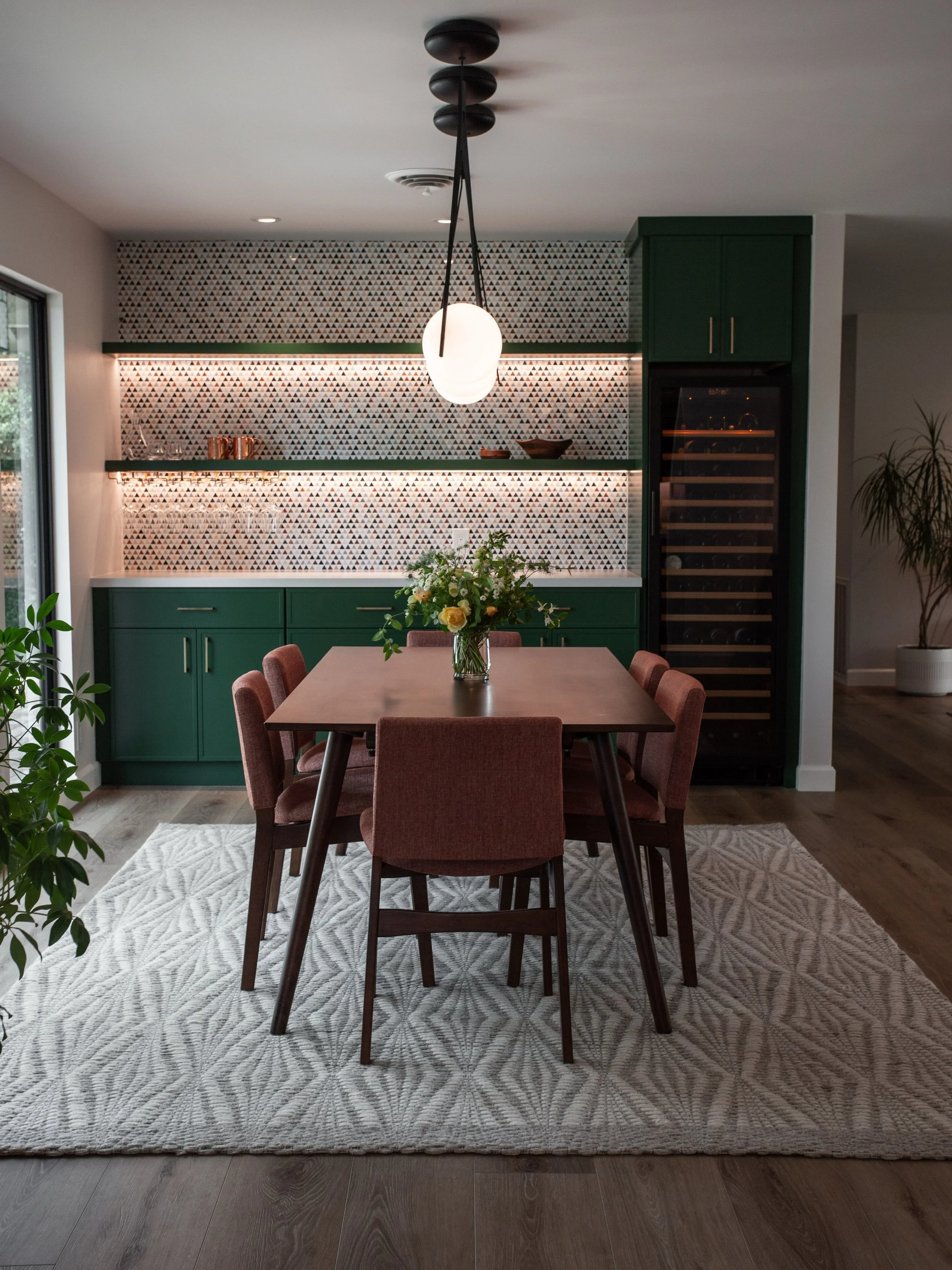 Our Midcentury Avenue Ranch project designed by Khara and Paige features a playful yet sophisticated design. Fun colors and geometric patterns paired with simplistic wood furniture set the stage in this dining space.