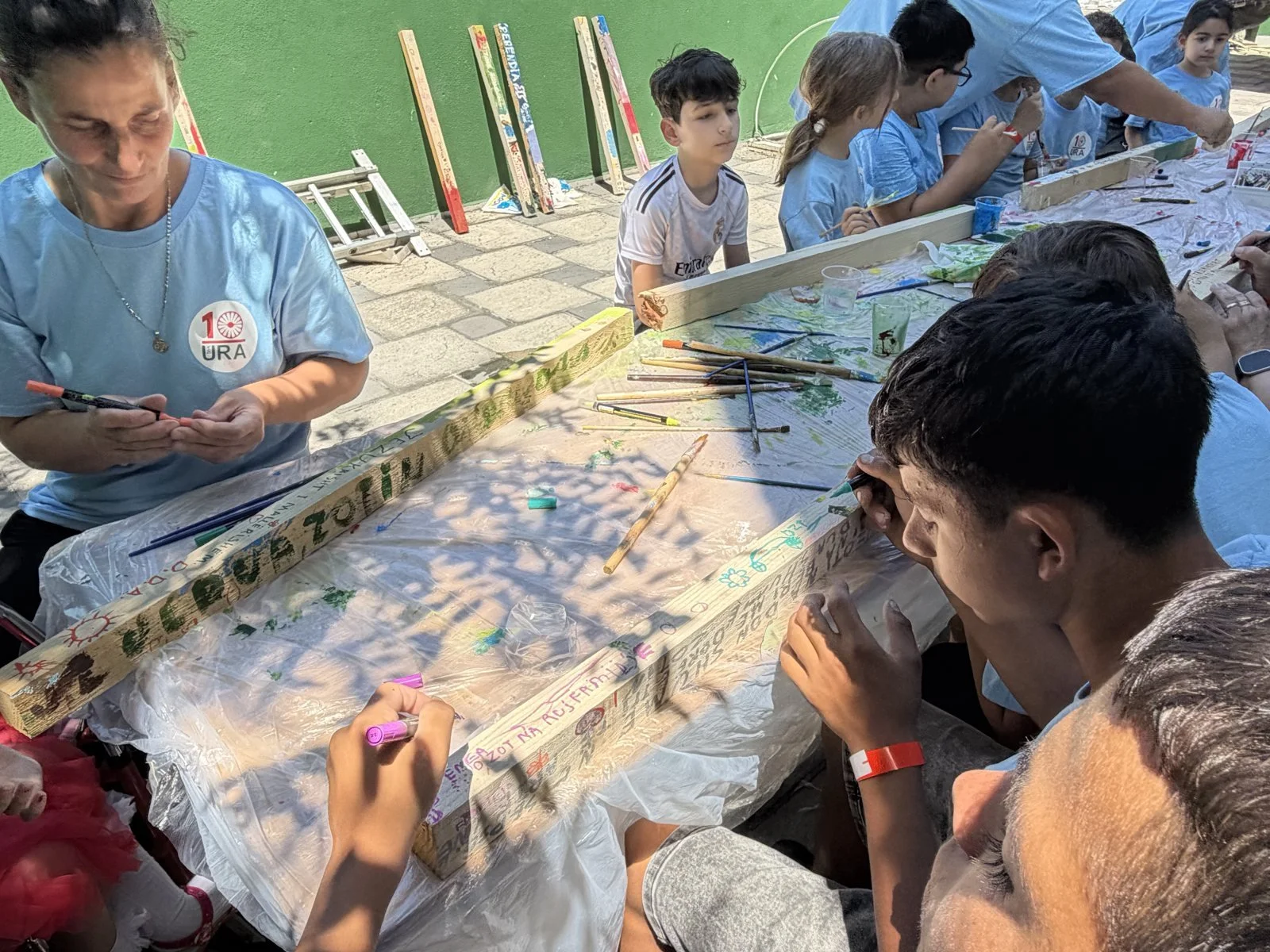 A painted plank carrying a name, a prayer, or a thank you