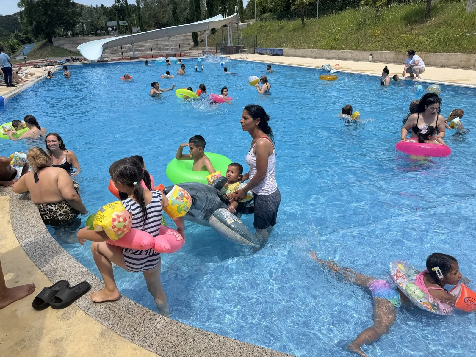Children playing in a swimming pool at Tek Ura summer camp
