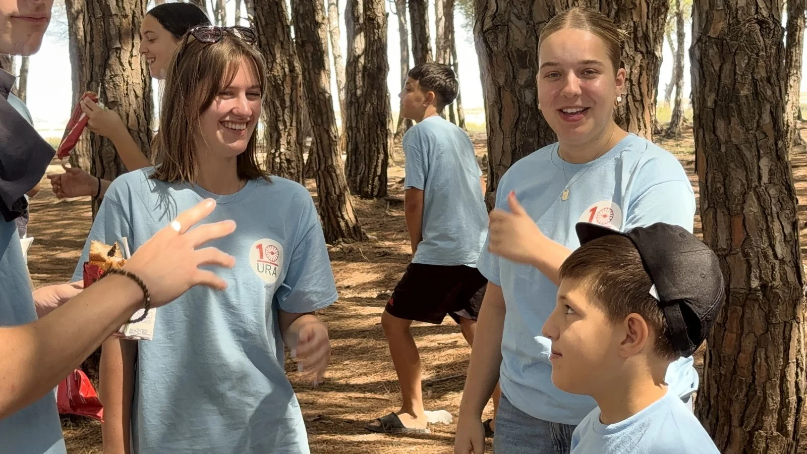Young adults in the pine woods at the Tek Ura summer camp in Albania