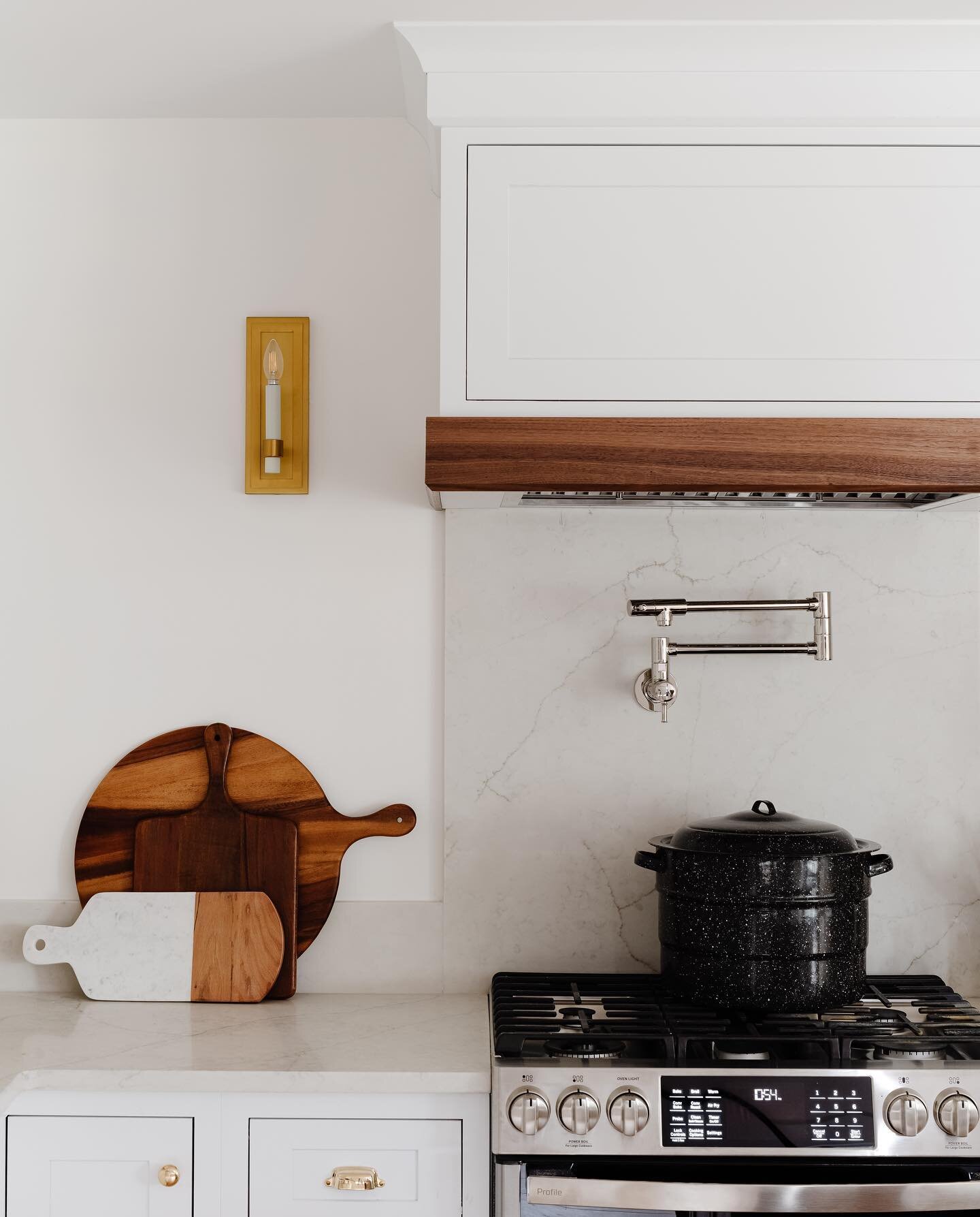 Simple can be so satisfying. We wanted this kitchen to have a paired back but sophisticated feel. We accomplished this by keeping the backsplash simple and utilizing less upper cabinetry so the hood could shine. The walnut hood detail was the perfect