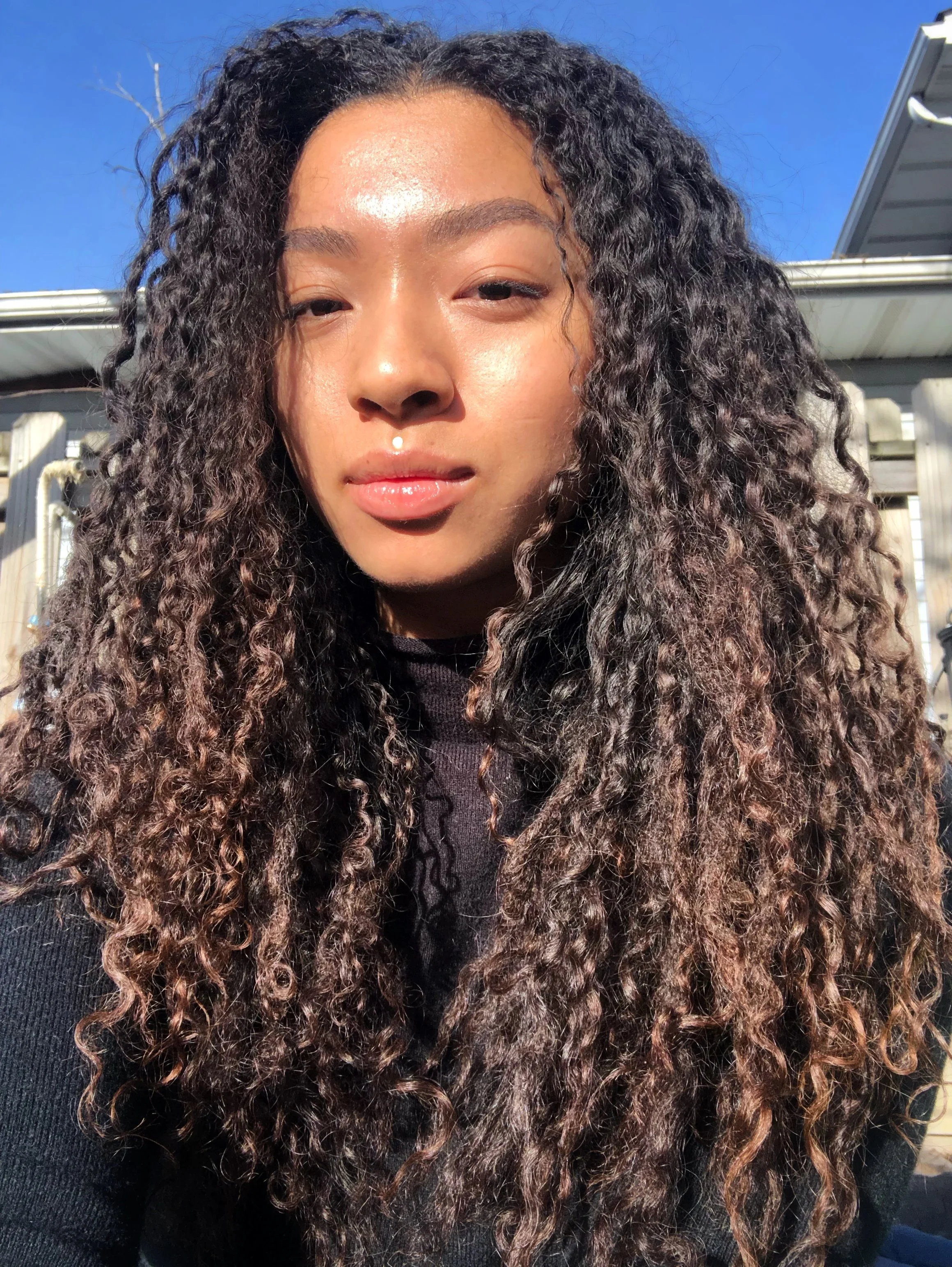 A photo of a light skin Black woman with curly dark brown hair