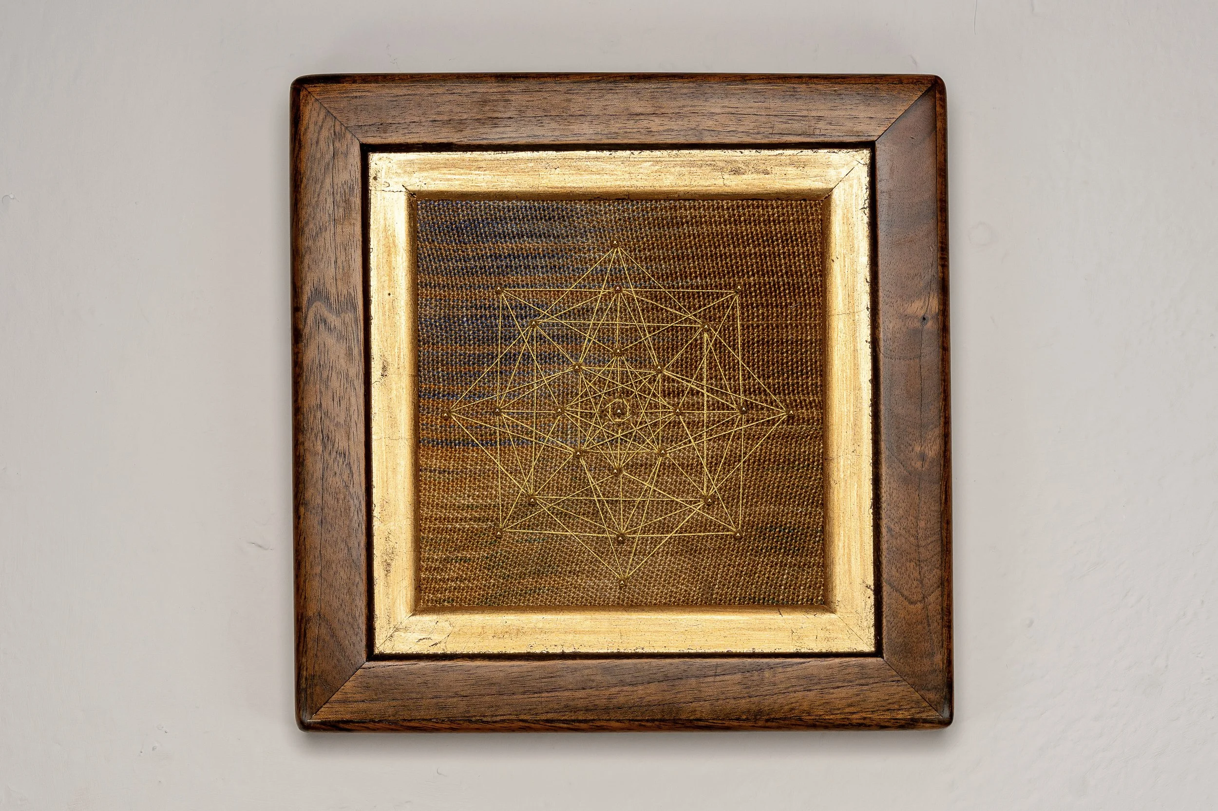 O-Cata-Shrah.    Handwoven textile with hand stitched geometric pattern.  Custom frame. 2025