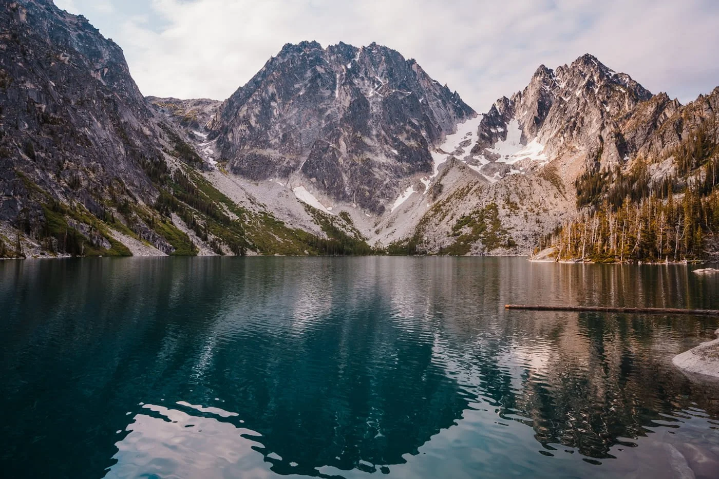a reflective colchuck lake with dragontail peak in the beackground