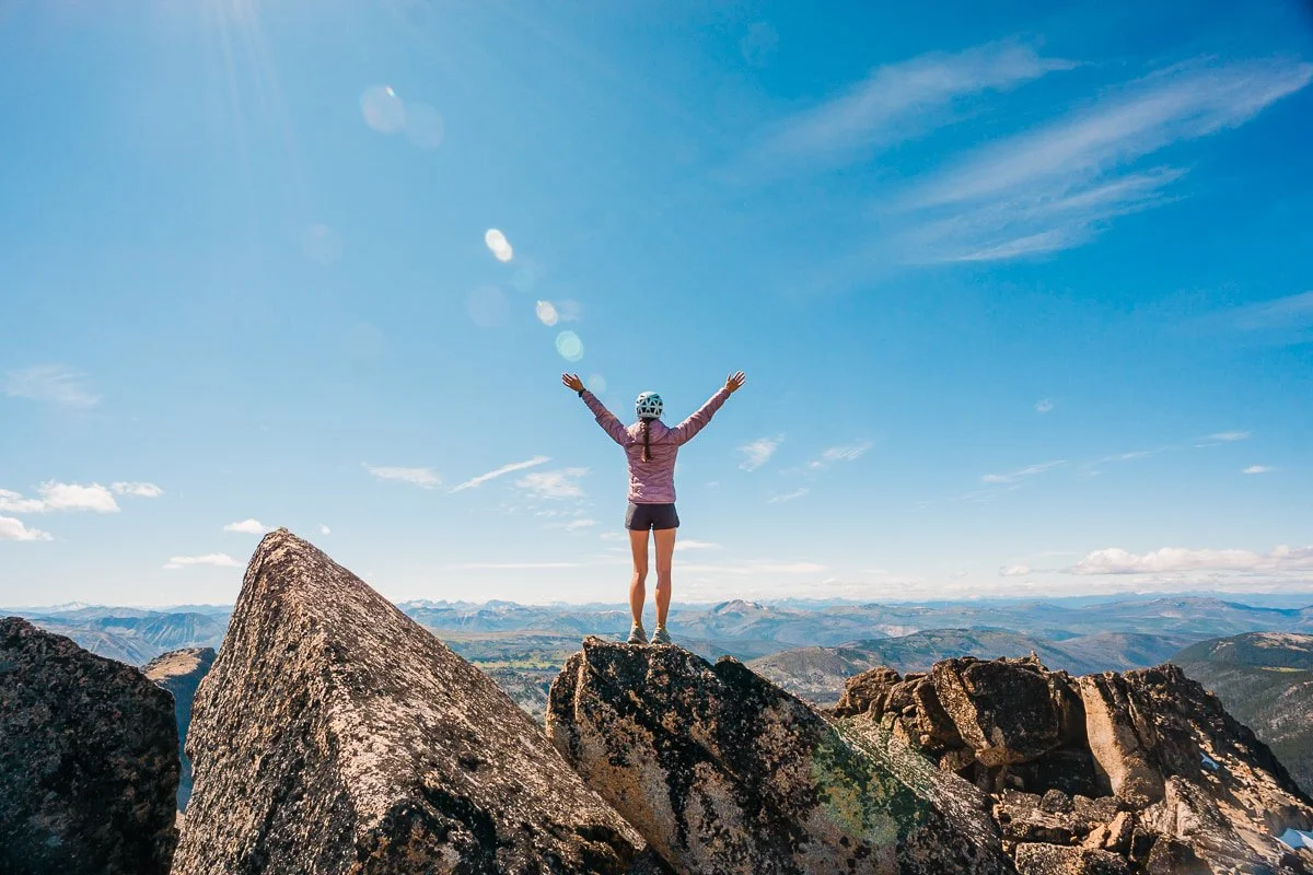 a scrambler standing on the summit of cathedral peak in the north cascades