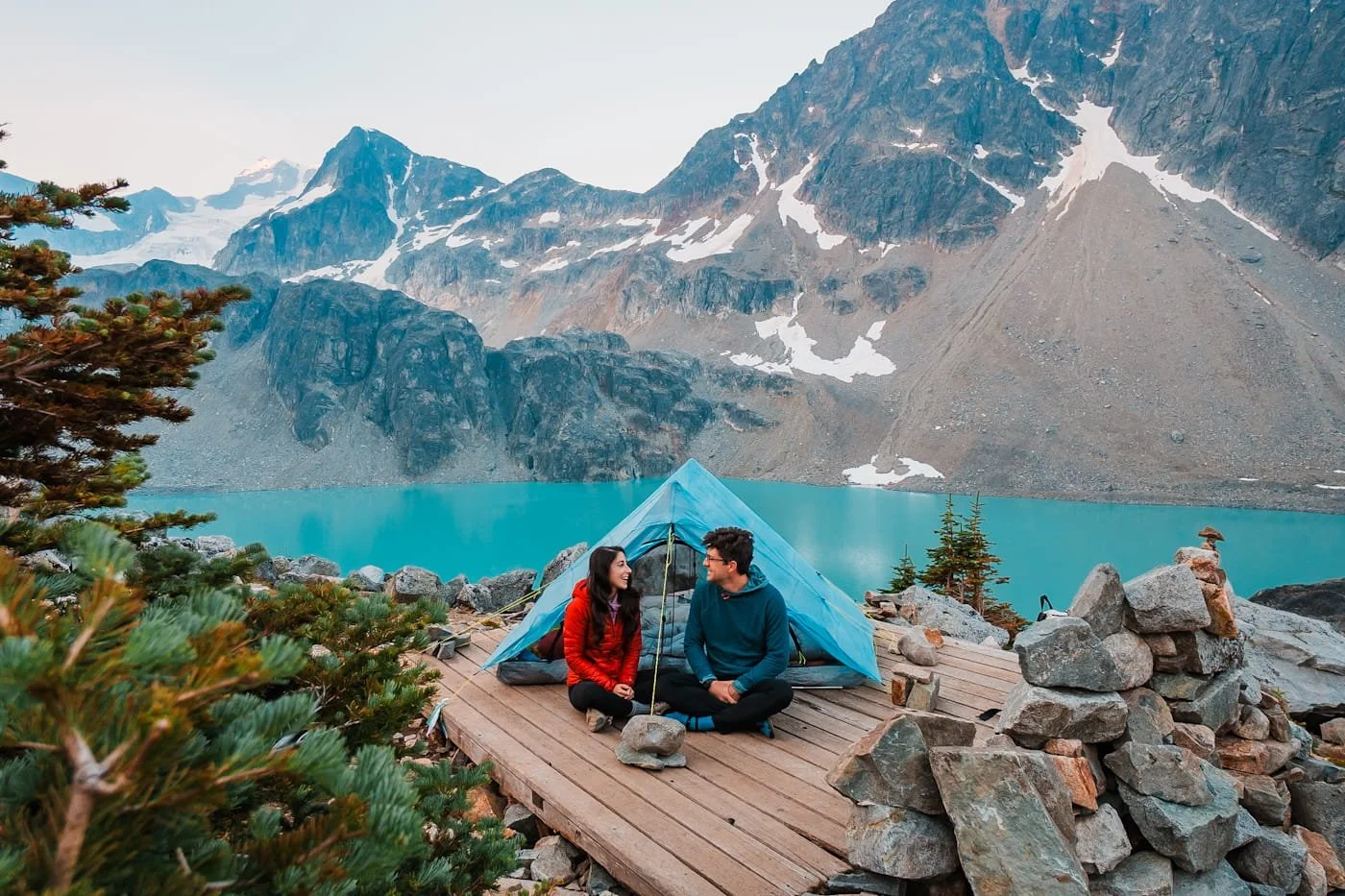 couple sitting on a tent platform at the upper wedgemount lake camping area