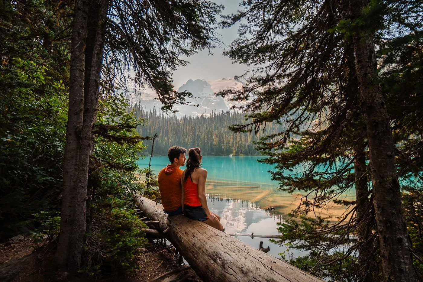 couple sitting on a log enjoying the view of middle joffre lake