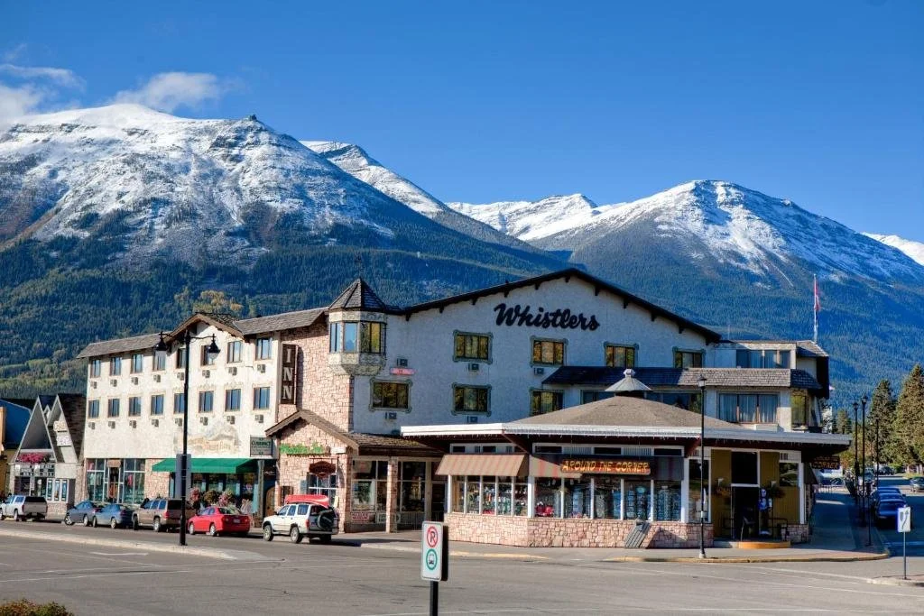 A bavarian looking hotel in downtown Jasper, with mountains in the background
