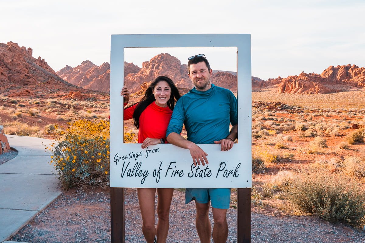 a couple standing behind a picture frame in valley of fire