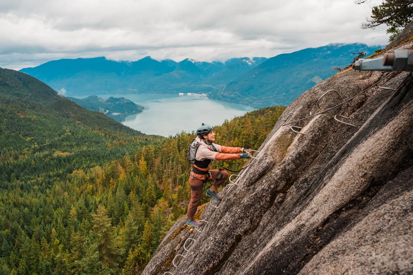 girl climbing up ladder along the squamish via ferrata