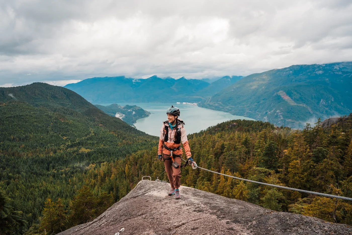 Girl walking along a steel cable a part the Squamish Via Ferrata at the top of the Sea to Sky Gondola
