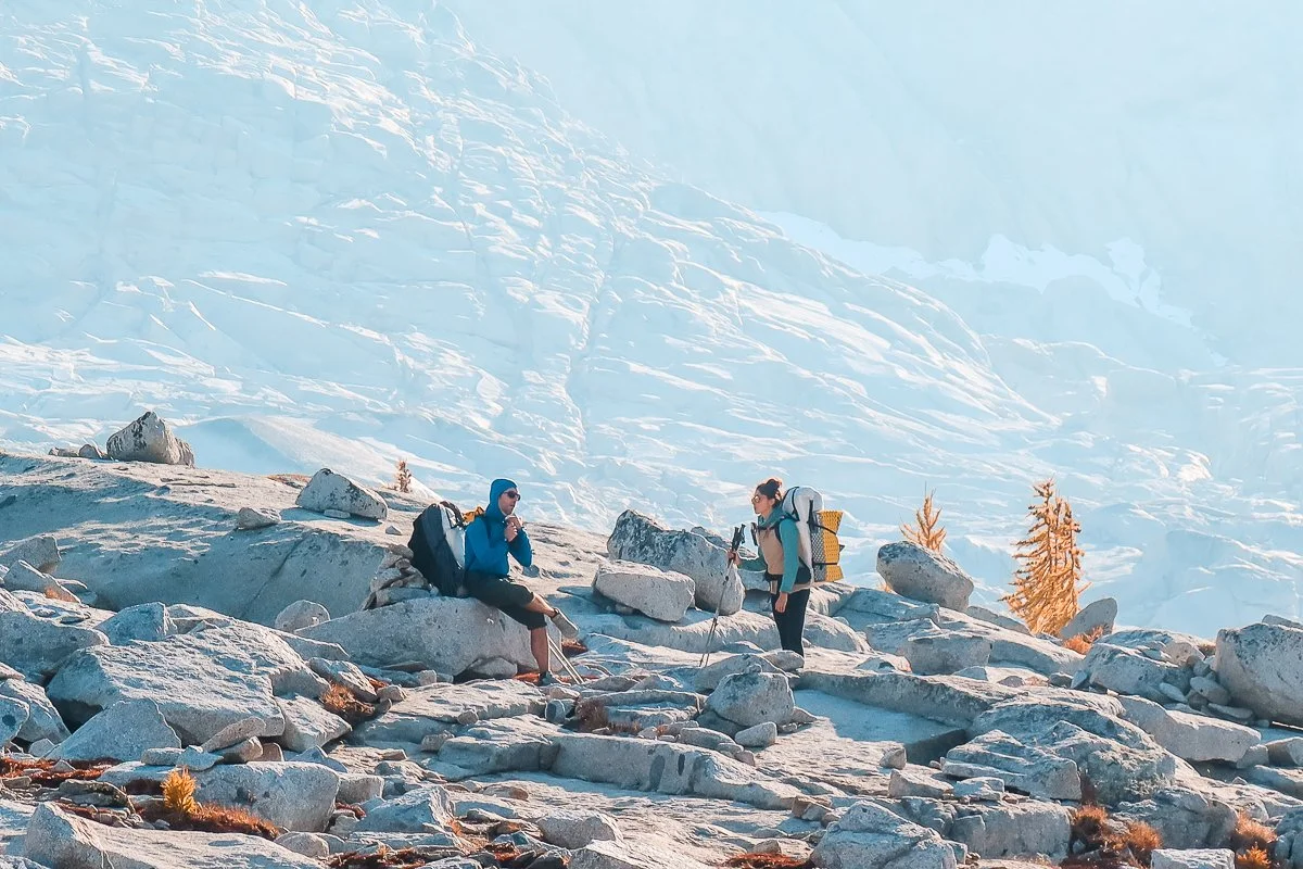 Two backpackers taking a break on rock slabs in the core enchantments