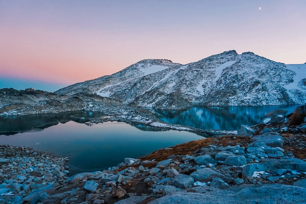 Blue hour just after sunset in the upper core of the enchantments, two calm, blue lakes, with mountains behind and a little snow