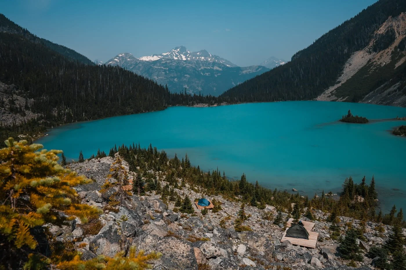 looking down at tents and tent platforms on a rocky ridge with a Upper Joffre Lake below