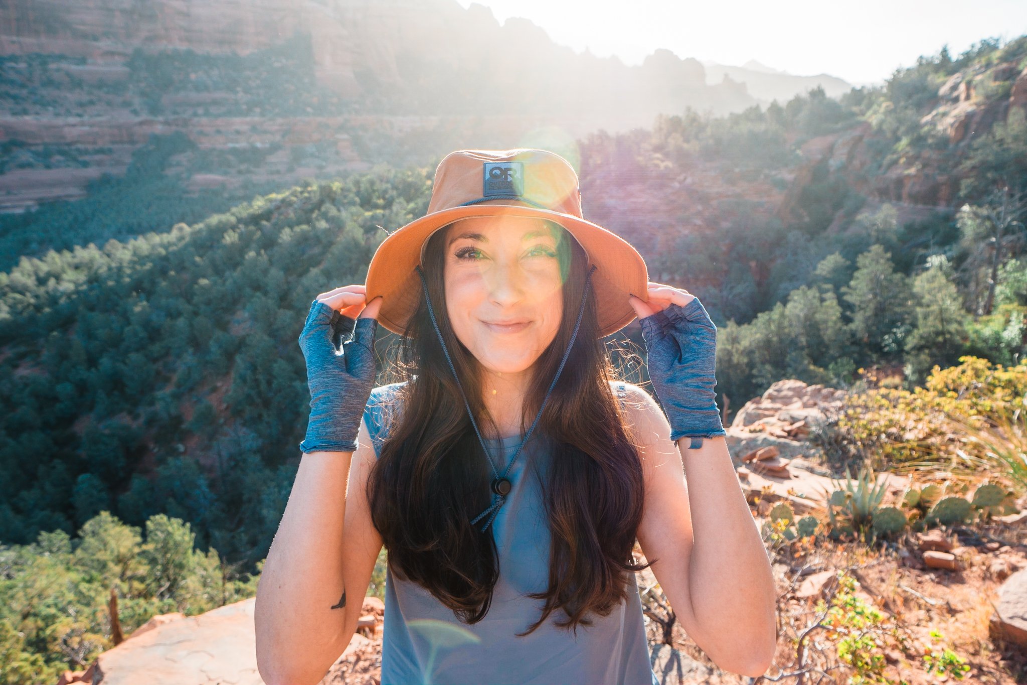 a women standing in the desert wearing a sun hat and sun gloves